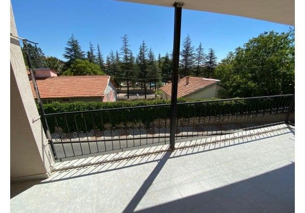 Oda balkonundan ağaçlık bahçe ve çam ağaçları manzarası