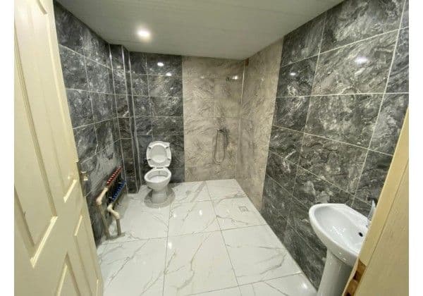 Oda içi banyo, mermer kaplama duş alanı ve lavabo