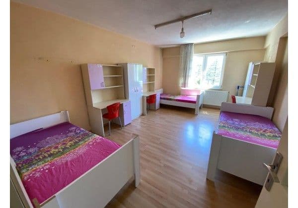 Üç kişilik odanın pencere tarafı, yataklar ve kişiye özel kitaplıklar
